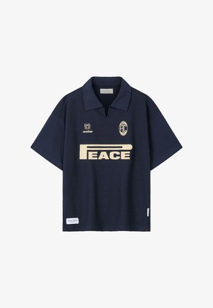 Lühikeste varrukatega meresinist värvi polo-särk kraega, millel on beežide tähtedega "PEACE" tekst, lilleline logo sõnaga "another" ning ovaalne "ACL 2023" vapp rinnal.