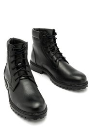 Czarne skórzane botki za kostkę o teksturowanym wykończeniu, okrągłym czubku, sznurowanym zapięciu, wyściełanym kołnierzem oraz solidnej gumowej podeszwie zapewniającej przyczepność.