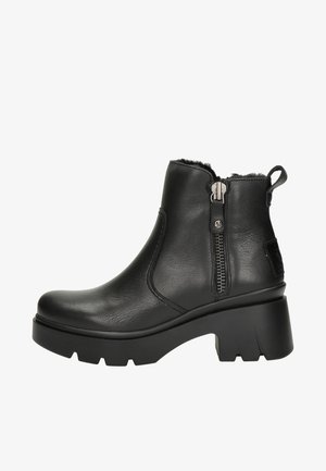 Botas de cuero negro hasta el tobillo con un cierre de cremallera lateral, puntera redondeada y suela de goma texturizada. Presentan un tacón bajo tipo bloque y un interior acolchado.