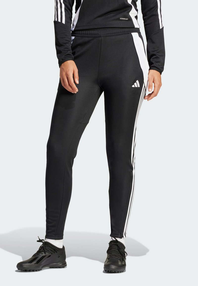 Black athletic pants with a slim fit, made from a smooth material. Features white side stripes and an Adidas logo on the left thigh.