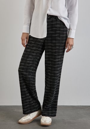 Schwarz-weiße karierte weit geschnittene Hose aus glattem Stoff, mit hoher Taille, seitlichen Taschen und einer entspannten Passform.