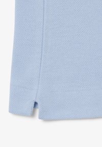 Vaaleansininen neulottu vaatekappale, joka on valmistettu teksturoidusta kankaasta ja jossa on sivuhalkiot helman kohdalla lisäyksinä yksityiskohtiin.