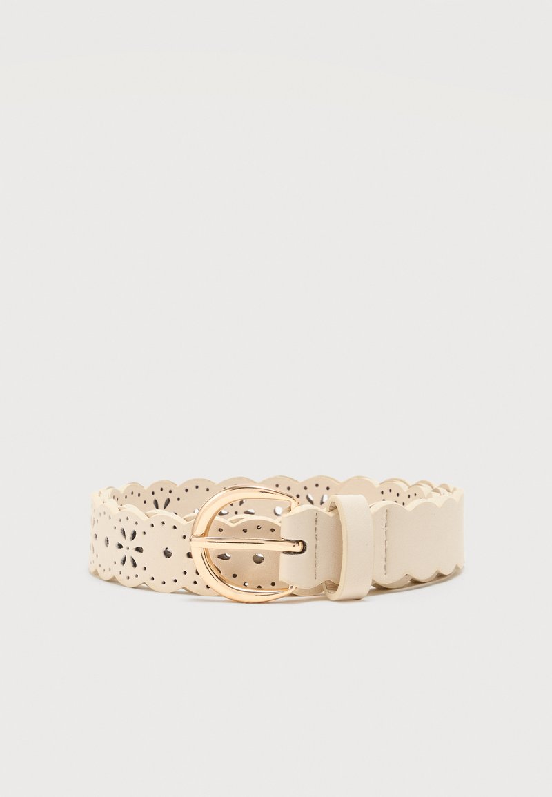 Ceinture en cuir couleur crème avec bords festonnés et motifs floraux découpés, avec une boucle ovale dorée sur un fond uni.