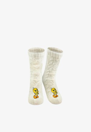 Cremefarbene, kabelgestrickte Socken mit dem gestickten Cartoon-Charakter Tweety Bird nahe den Zehen.