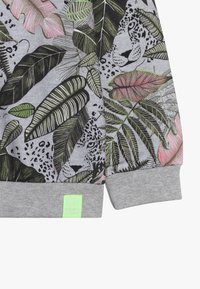 Szary sweatshirt z tropikalnym motywem liścia i wzorem z panterą. Znaczące akcenty w kolorach zielonym, różowym i czarnym; ściągacze na rękawach i u dołu.
