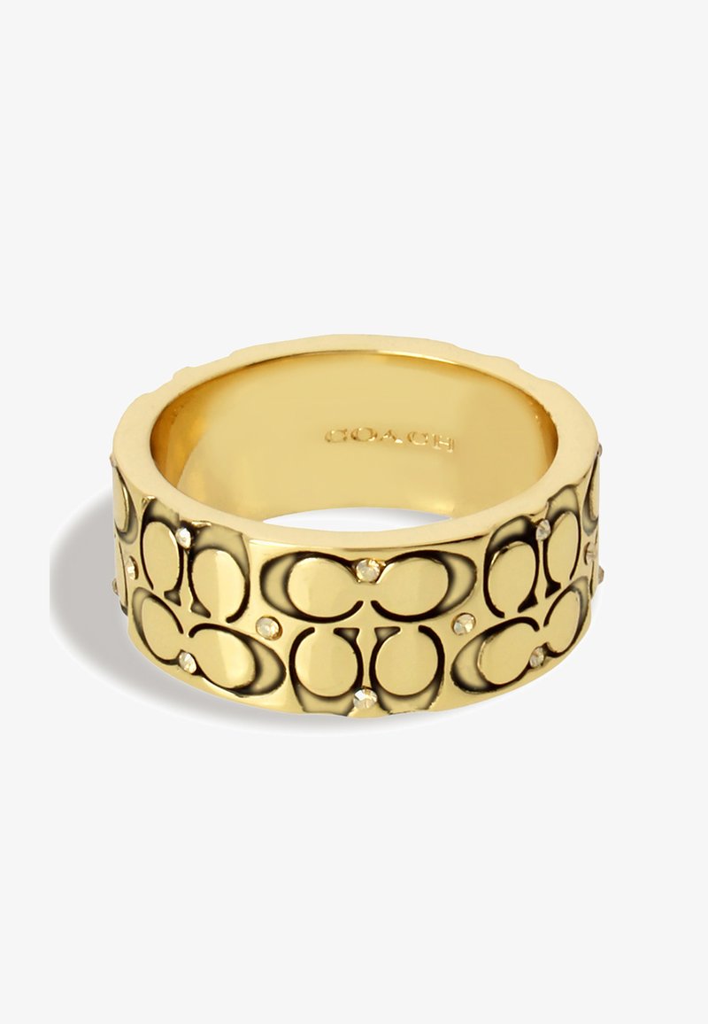 Kultaketju, jossa on kohokuvioitu kuosi ja pieniä kirkaita kristalleja. Sileä sisäosa, teksturoitu ulkopinta, jossa on päällekkäin olevia logoja. Kiiltävä pinta.