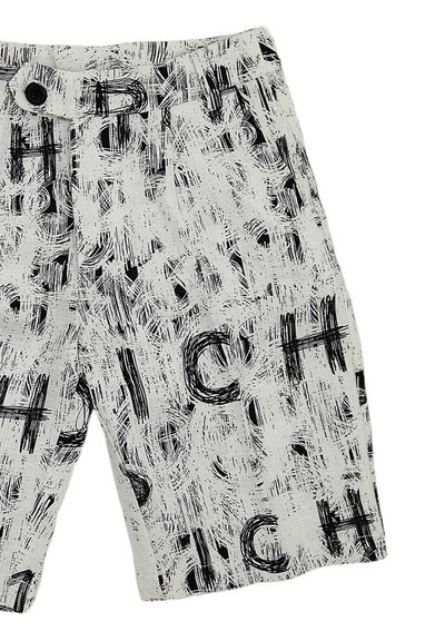 Pantaloni corti bianchi con un motivo astratto nero che presenta la ripetizione della parola "CH" in dimensioni variabili. Realizzati in tessuto leggero con chiusura a bottone.