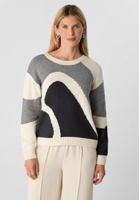 Strickpullover mit geometrischem Muster in Creme, Schwarz und Grau. Rundhalsausschnitt, gerippte Bündchen und Saum mit lässiger Passform.