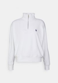 Pullover in pile bianco con colletto alto, mezza zip e logo blu navy discreto sul lato sinistro del petto. Texture morbida, polsini e orlo a coste.