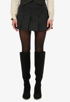 Short black pleated skirt with white pinstripes, paired with black thigh-high boots. The fabric appears smooth with a tailored fit.