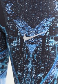 Leggings Nike neri con un motivo geometrico blu, dotati di un logo argento. Realizzati in materiale elasticizzato, con un design aderente.