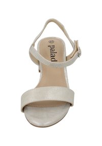 Sandalia de tacón alto beige con un acabado texturizado, que presenta una amplia correa frontal y una correa para el tobillo ajustable asegurada con una hebilla.