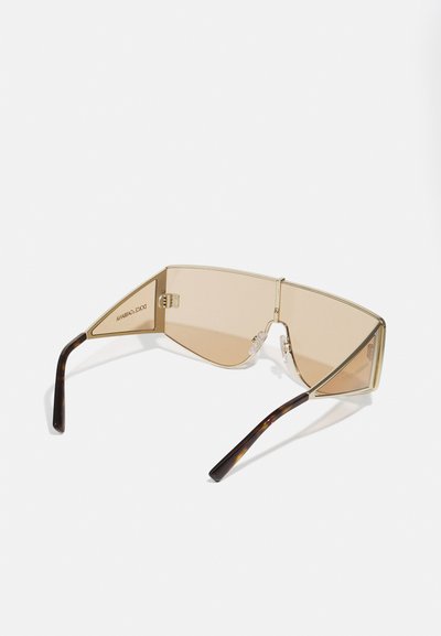 Ochelari de soare cu lentile mari, unghiulare, de culoare maro și o ramă din metal aurie. Temelurile au un model de fildes, oferind un contrast cu rama.