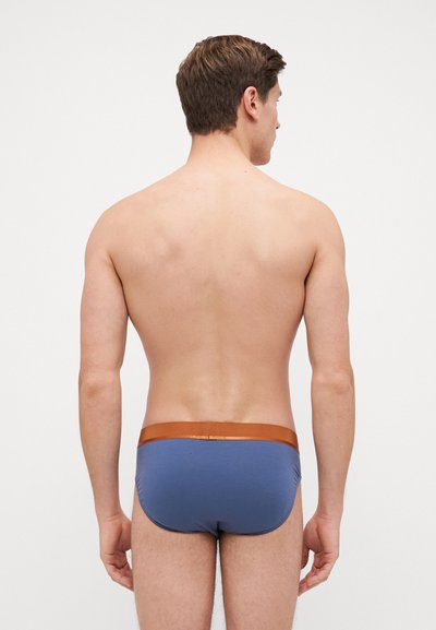 Slip-uri de înot dintr-un material albastru închis, cu o textură netedă și o talie elastic�ă maro în contrast. Design simplu, ajustat.