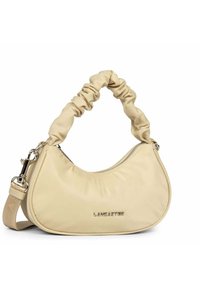 Sac à main en tissu beige, de forme arrondie, avec une anse froncée, une fermeture éclair argentée et un logo en relief sur le côté. Sangle réglable incluse.