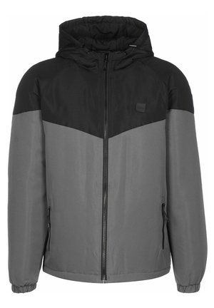 Veste d’hiver à capuche pour homme avec partie supérieure noire, partie inférieure et manches grises, fermeture éclair avant et poches latérales zippées.