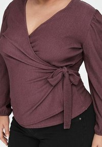 Bordeauxrode wikkel top met lange pofmouwen, gestructureerde stof, V-hals en een gespen detail in de taille. Klassiek, getailleerd silhouet.