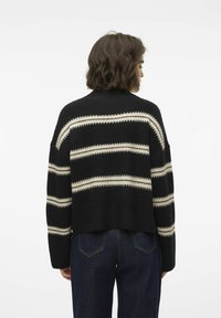 Maglione a righe nero e crema con design cropped, dettagli a coste sui polsini e sull'orlo, tessuto morbido e vestibilità comoda.