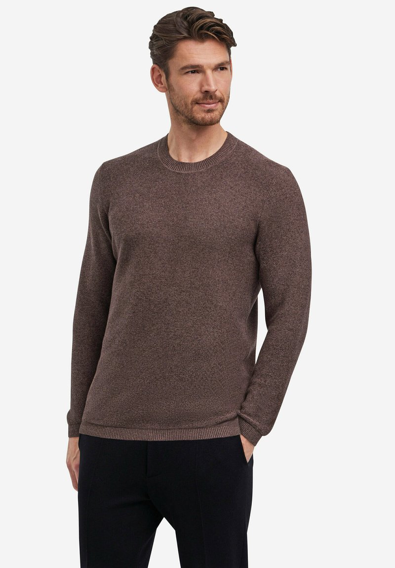 Brauner Strickpullover mit Rundhalsausschnitt, gerippten Bündchen und Saum. Verfügt über eine strukturierte Oberfläche und eine figurbetonte Passform. Wird über dunklen Hosen getragen.