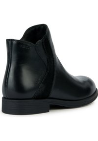 Stivale alla caviglia in pelle nera con accenti in suede, punta rotonda, tacco basso impilato e dettagli cuciti. Presenta un logo del marchio sul lato.