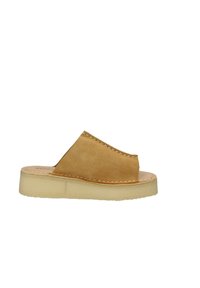 Sandal in suede tan, con punta aperta arrotondata, dettagli cuciti e suola traslucida leggera. Texture liscia e design minimal.