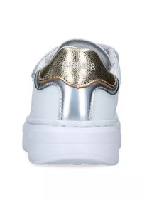 Sneaker bianco con un accento testurizzato in oro sul tallone, dettagli in argento metallico e una suola bianca spessa. Il nome del brand è visibile.
