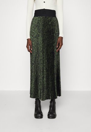 Groene geplooide maxirok met een zwarte tailleband met geperst logo. Textuur in het gehele slangenprintpatroon. Gecombineerd met zwarte enkellaarsjes.