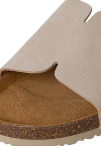 Bež sandala na slip-on s teksturiranom gornjom strukturom, obloženim korkom i mekim nubuk unutrašnjim dijelom, s zakrivljenim izrezanim dizajnom.