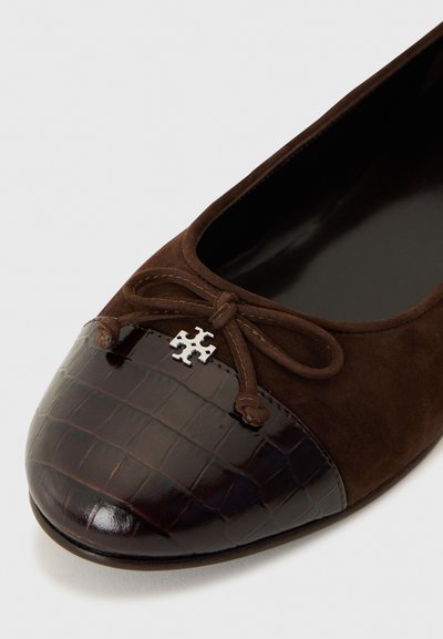 Ballerines en nubuck marron avec un embout en croûte de cuir brun foncé brillant; dotées d'un nœud avec un accent logo en argent au centre.