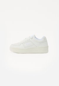 Balti sneakersai su lygiu odiniu viršumi, perforuota nosimi, paminkštintu apykakle ir storu guminėmis padais. Šone yra subtilus logotipas.