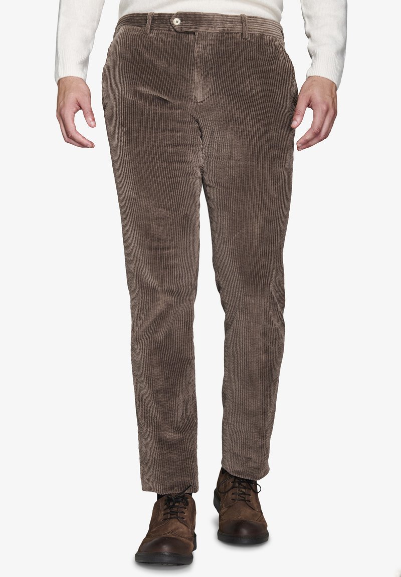 Braune Cordhosen mit vertikaler Ripptextur, slim-fit Design, Knopfverschluss, verstärkte Taschen, kombiniert mit dunklem Schuhwerk.