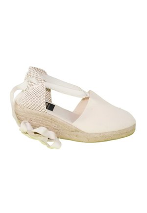 Alpargata de cuña blanca con lazos para atar en el tobillo y detalle trenzado en el talón sobre suela de yute, mostrada de perfil.