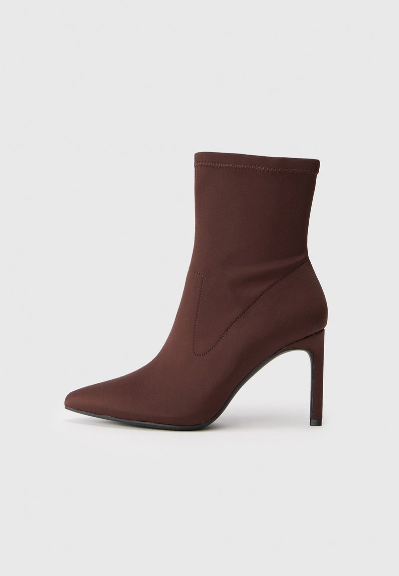 Brown stretch fabric ankle boot with pointed toe and 10 cm stiletto heel. Seam detailing along the sides, smooth texture, and no visible fastenings.