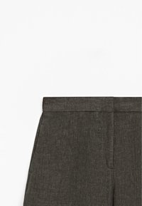 Pantalon gris foncé taillé avec une ceinture plate et des poches latérales, vu de la taille vers le bas sur fond blanc.