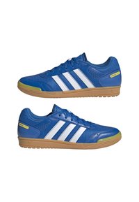 Baskets de sport bleues avec des rayures blanches, en cuir et en maille, à bout rond, semelle en caoutchouc gum surélevée, et accents jaunes étiquetés "Special Light."