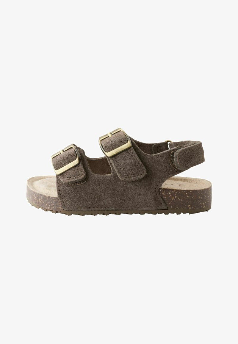 Sandale en daim marron avec deux brides réglables à boucle et une bride à velcro à la cheville, avec une semelle en liège rembourrée.