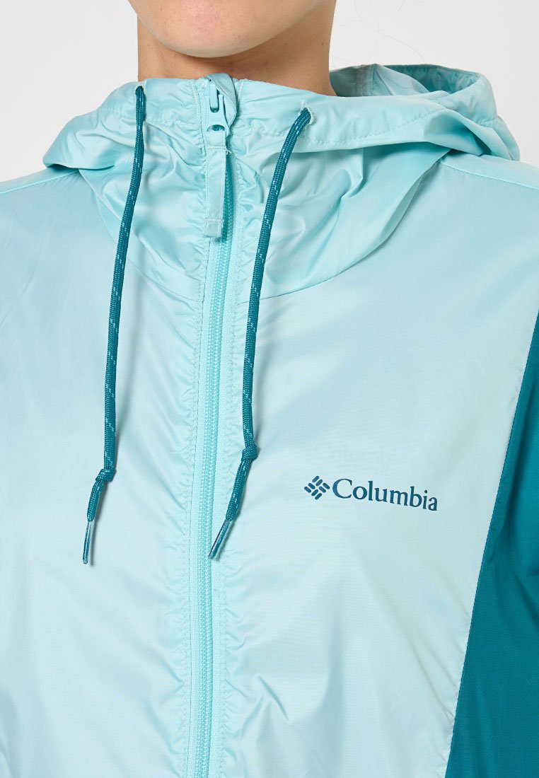 Hellblaue Columbia-Jacke mit Reißverschluss, verstellbarem Kapuzenzug und türkisfarbenen Akzenten. Sie besteht aus atmungsaktivem Material und hat ein Logo auf der linken Seite.