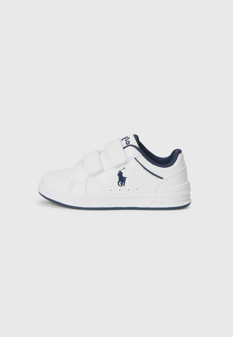 Witte kinderschoenen met marineblauwe accenten, gemaakt van synthetisch materiaal, met twee verstelbare klittenbandriemen en een logo aan de zijkant.
