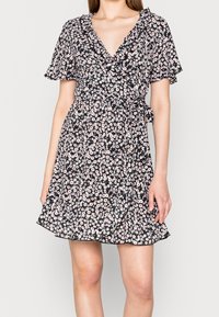 Robe portefeuille noire à fleurs avec des manches courtes à volants, ornée de fleurs roses et blanches, avec une taille cintrée et un ourlet évasé.