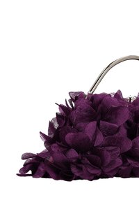 Bolso morado con diseño floral hecho de tela texturizada; cuenta con un asa plateada y un cuerpo fruncido con detalles en forma de pétalos superpuestos.