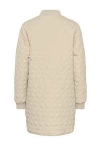 Veste beige matelassée avec un motif en losanges, un col et des poignets côtelés, et une silhouette longue et droite, présentant une texture lisse.