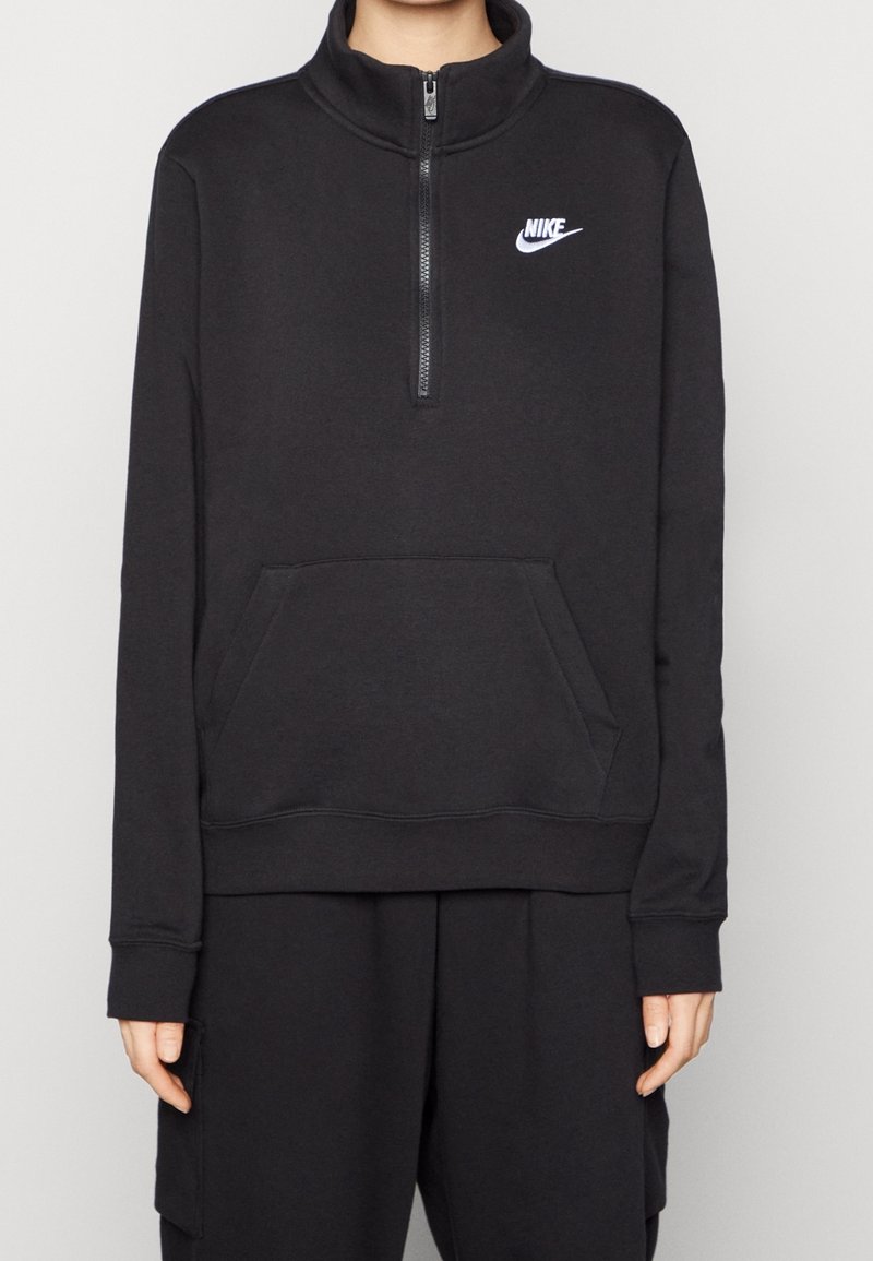 Svart zip-up fleece-tröja med hög krage, framficka i känguru-stil och vit Nike-logotyp på bröstet. Mjuk textur, avslappnad passform.