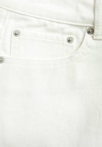 Beli denim tkanina z teksturiranim črtastim vzorcem, opremljena z kovinskimi zakovicami na žepih in čistim, preprostim dizajnom.