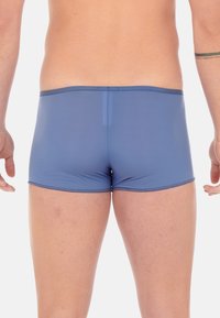 Herren Boxer-Shorts in Blau, hergestellt aus elastischem Material, mit einer glatten Textur, geschlossenen Nähten und einer engen Passform an der Taille und den Beinen.