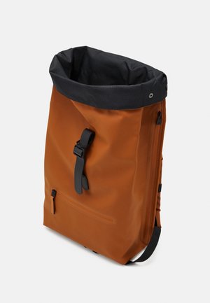 Plecak typu roll-top w kolorze rdzy z czarną górną krawędzią, przednim paskiem z klamrą, przednią kieszenią zapinaną na zamek i bocznym zamkiem błyskawicznym na białym tle.