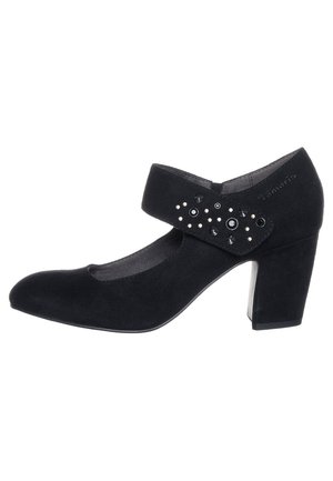 Mustat mokkanahkakengät, joissa on pyöreä kärki, nilkkastrappi ja koristeltu erilaisilla niiteillä sivuilla. Loivasti korotettu kanta vakauden takaamiseksi.