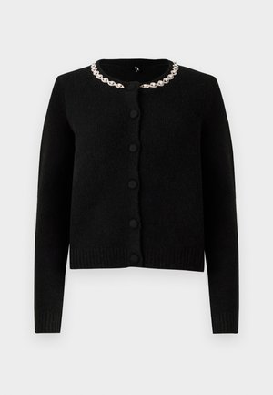 Cardigan noir en tricot avec des manches longues, un col rond et une fermeture à boutons. Équipé d'un collier décoratif en chaîne argentée. Texture douce.
