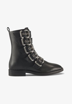 Botte noire en cuir avec cinq brides à boucles argentées et un talon bas, vue de profil sur fond blanc.