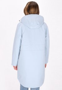 Geacă impermeabilă de culoare albastru deschis, cu glugă, mâneci lungi și un design de lungime medie, cu un tiv ușor curbat. Textură netedă, cu îmbinări minime.