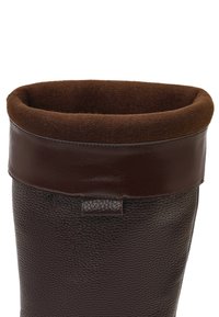 Bruine leren laars met een gestructureerd lichaam en een gladde, donkerbruine manchet. De binnenkant is gevoerd met zacht stof voor comfort.